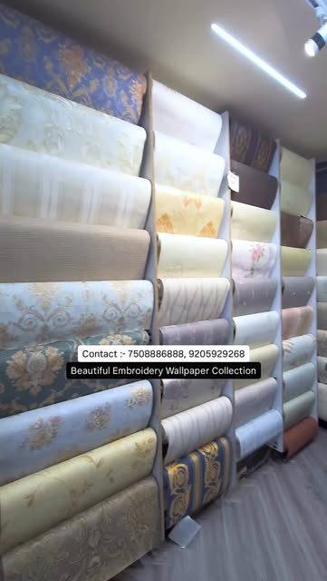 Racks of embroidery wallpaper rolls in the Wall Co. showroom