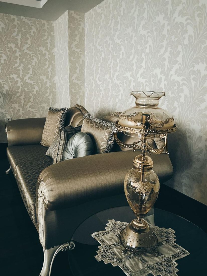 Living room with damask wallpaper and a velvet sofa