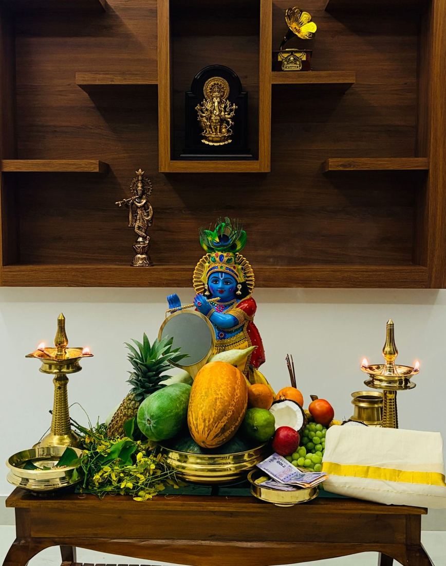 Home pooja corner with a wooden backdrop and brass lamps